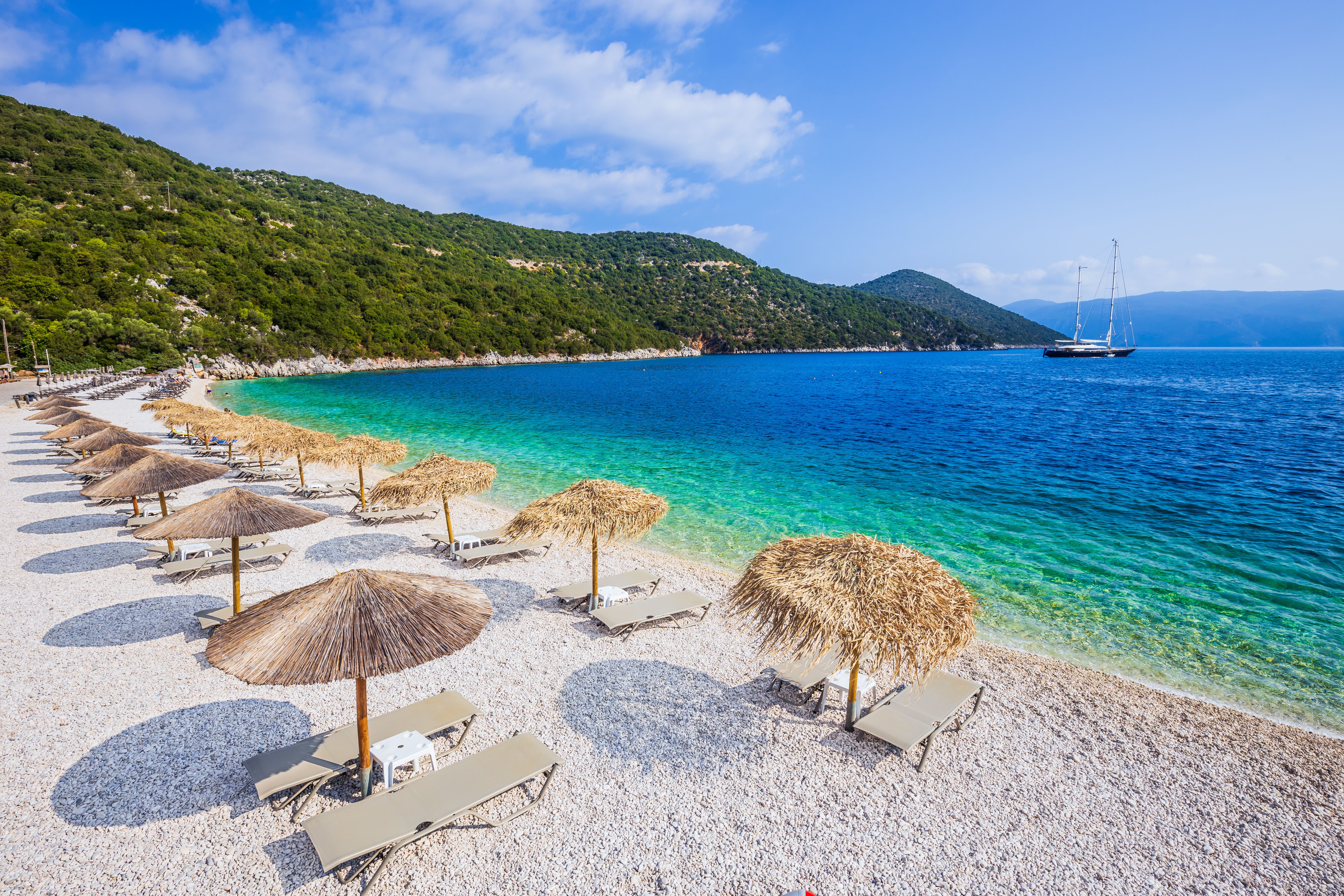 A view of sun loungers and thatch umbrellas on Antisamos beach in Kefalonia, Greece