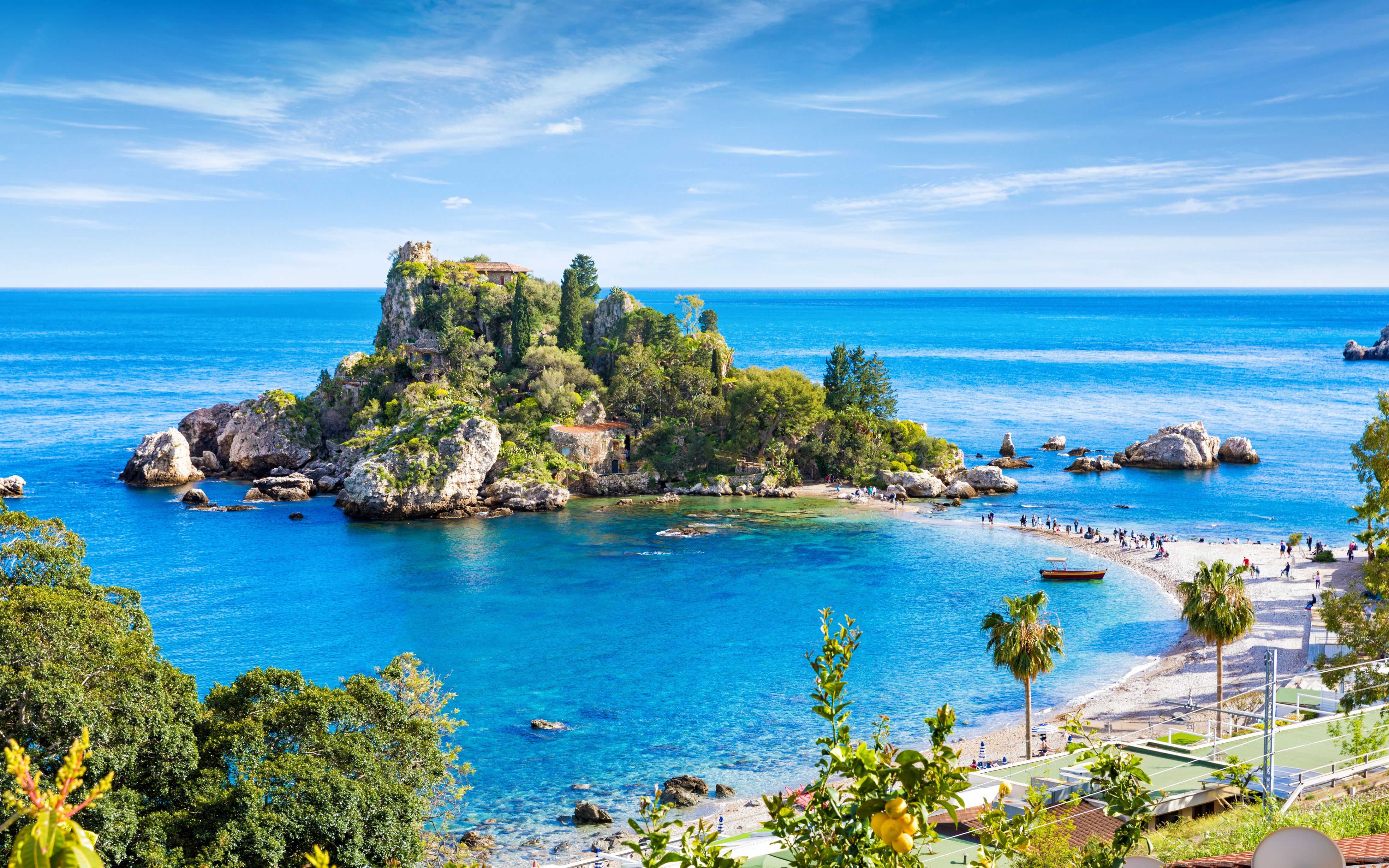 View of the rocky, tree-covered island of Isola Bella, connected to mainland Taormina by a narrow sandbar