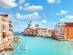 A view of the houses and basilica on Venice's Grand Canal with fluffy white clouds in the sky