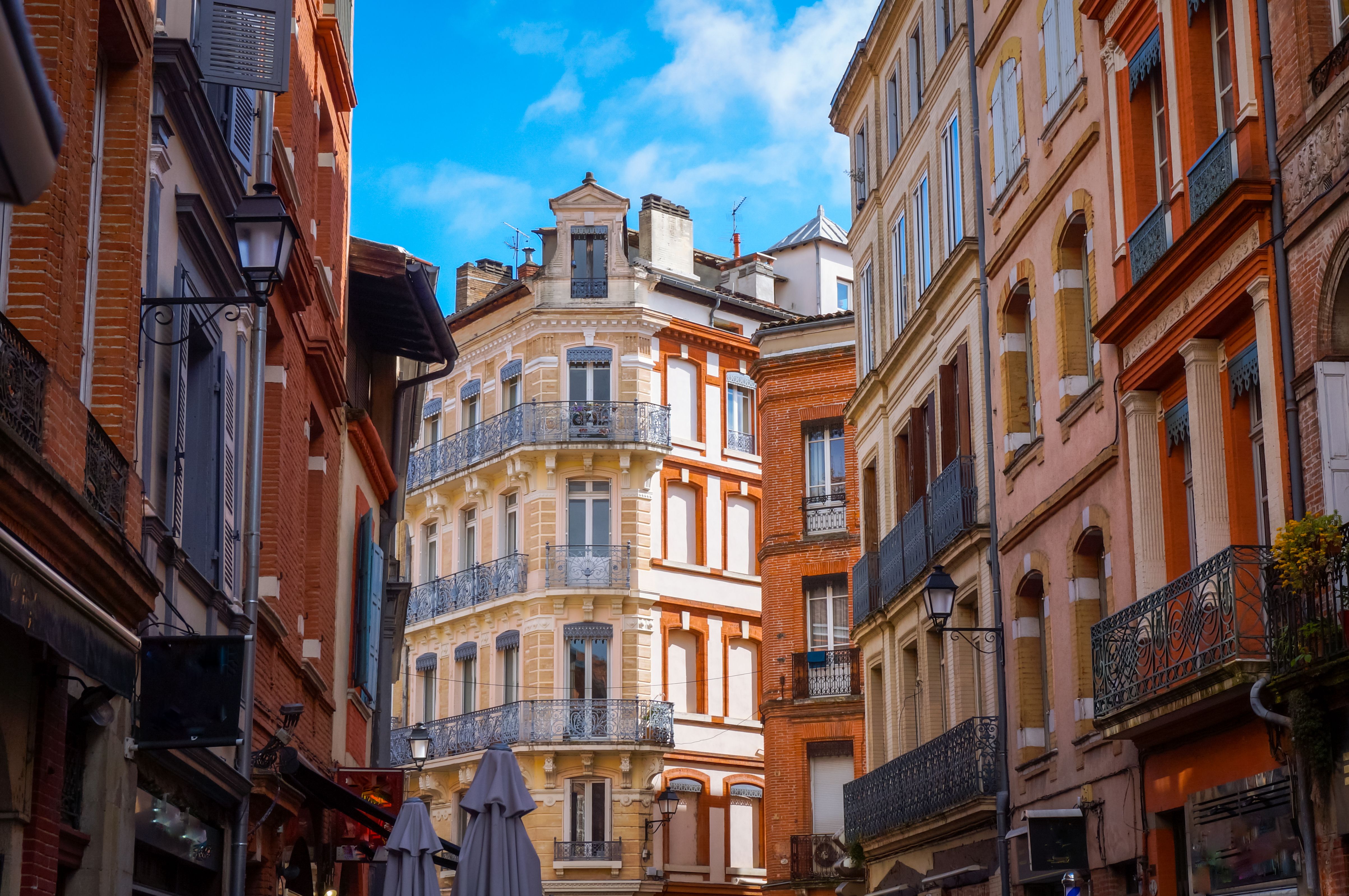 View down a colourful street looking towards a multi-storey yellow building.