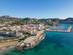 Aerial drone shot of Moraira, a coastal town with a marina surrounded by low mountains