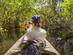 View of a woman kayaking through mangrove forests in the USA.
