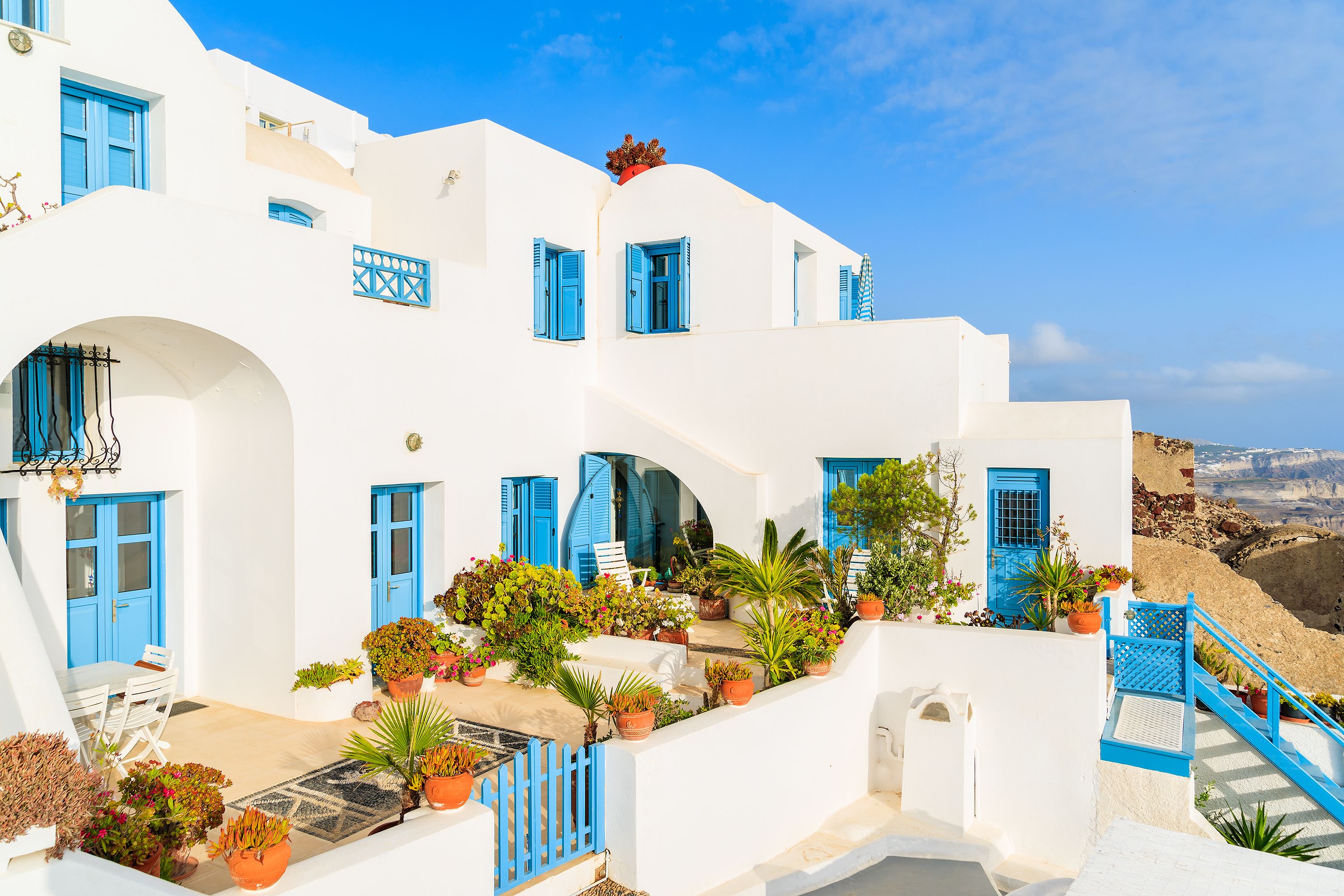 A brilliantly white two-storey villa with light blue doors and windows in Imerovigli in Santorini