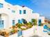 A brilliantly white two-storey villa with light blue doors and windows in Imerovigli in Santorini