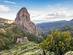 View of Roque Agando rising above a green valley with flowers in La Gomera