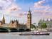 View of Big Ben, the Houses of Parliament and Westminster Bridge with a ferry sailing along the Thames in the foreground at sunset