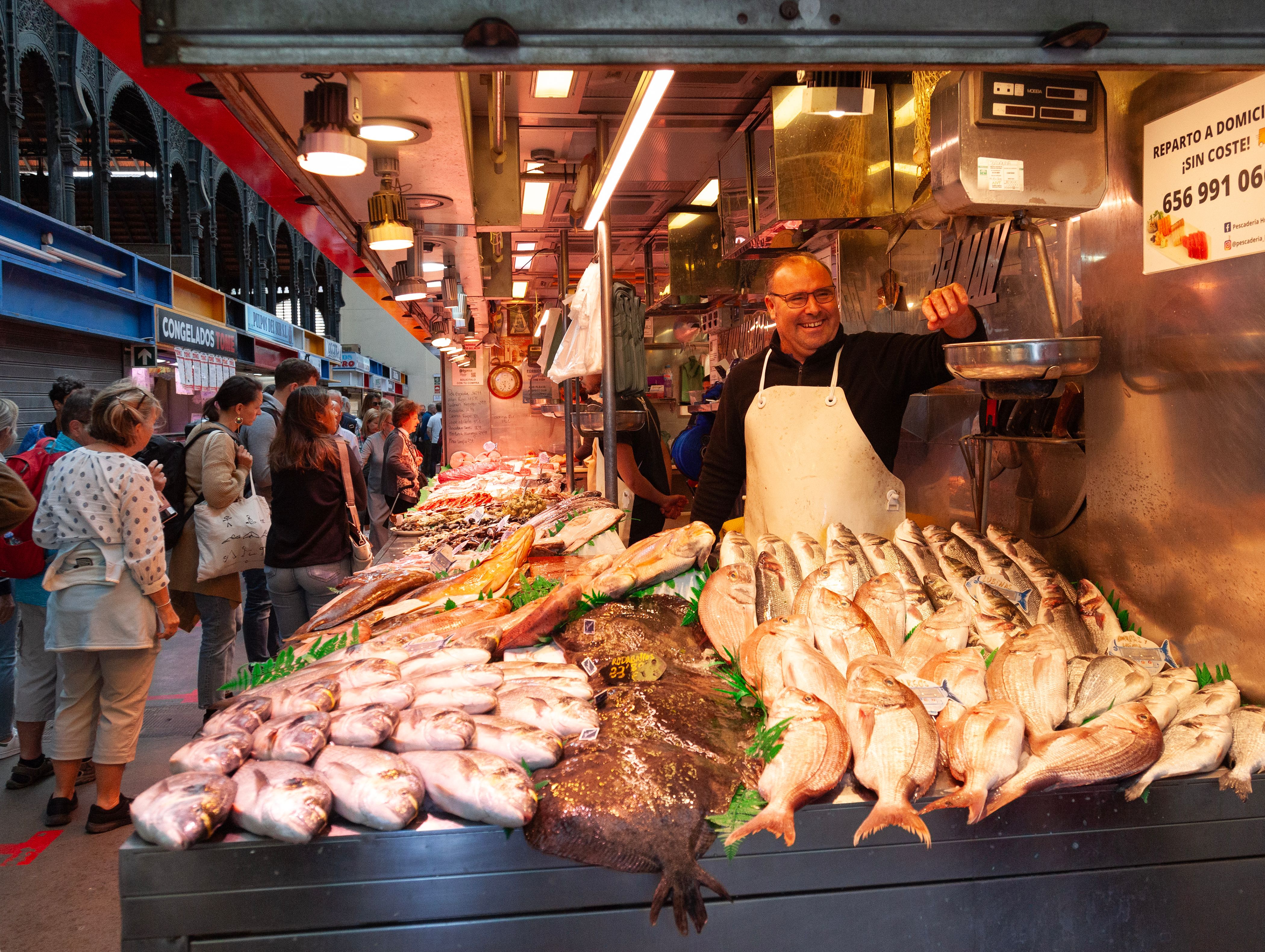 A smiling fishmonger in his fish stall at Mercado Central de Atarazanas, the food market in central Málaga.