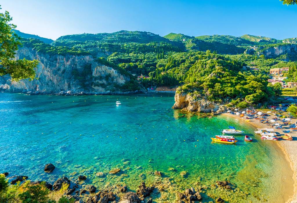 A view of a beach and boats in Paleokastritsa on Corfu, Greece