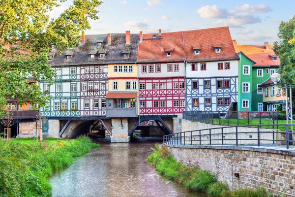 A medieval arch bridge with half-timbered shops and houses in a variety of colours in Erfurt