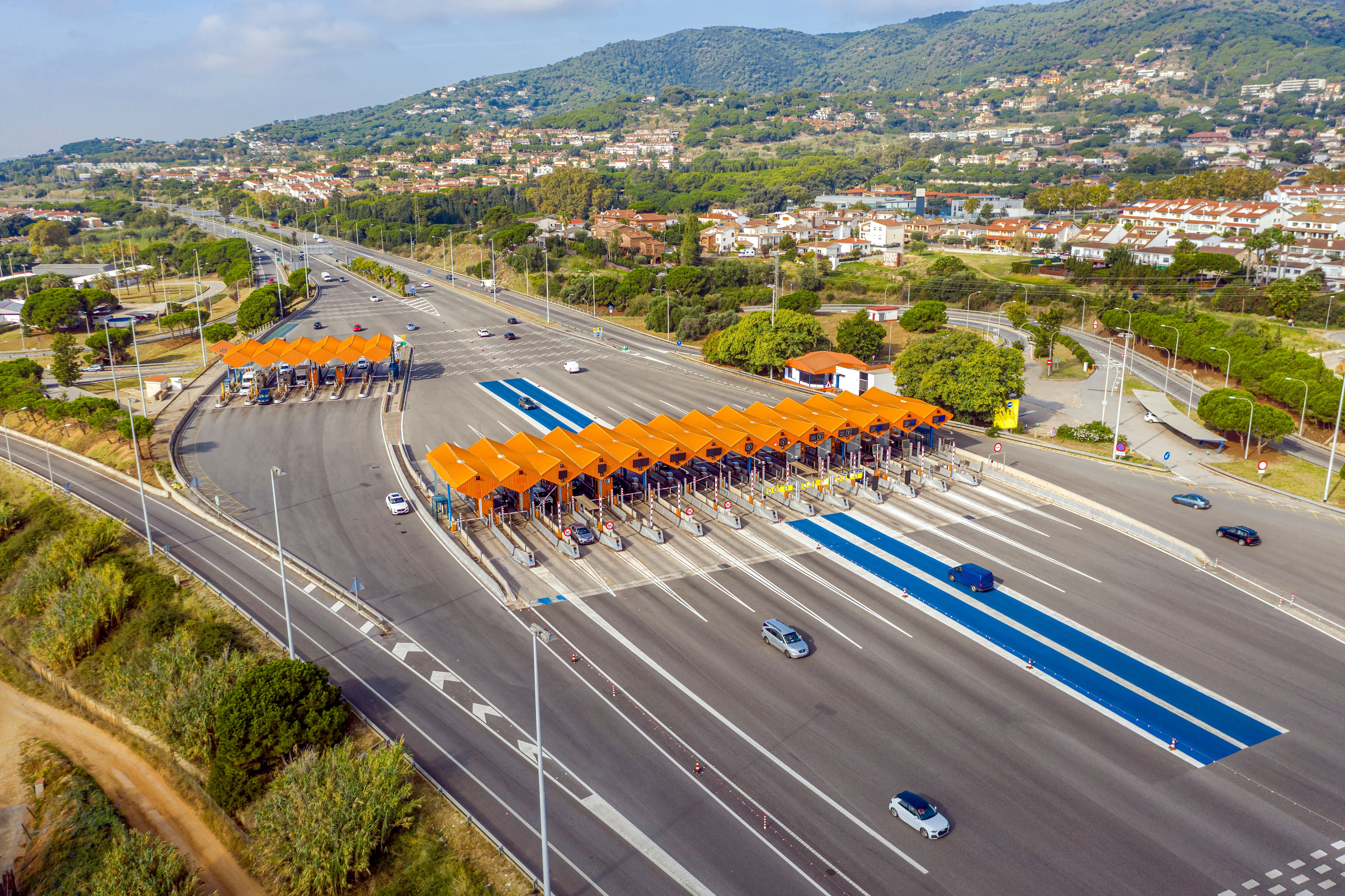 An aerial view of cars passing through a road toll point in Spain
