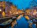 A view of canal in Amsterdam at Christmas with fairy lights decorating the trees