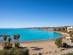 View of an empty horseshoe-shaped beach on a sunny day in Spain