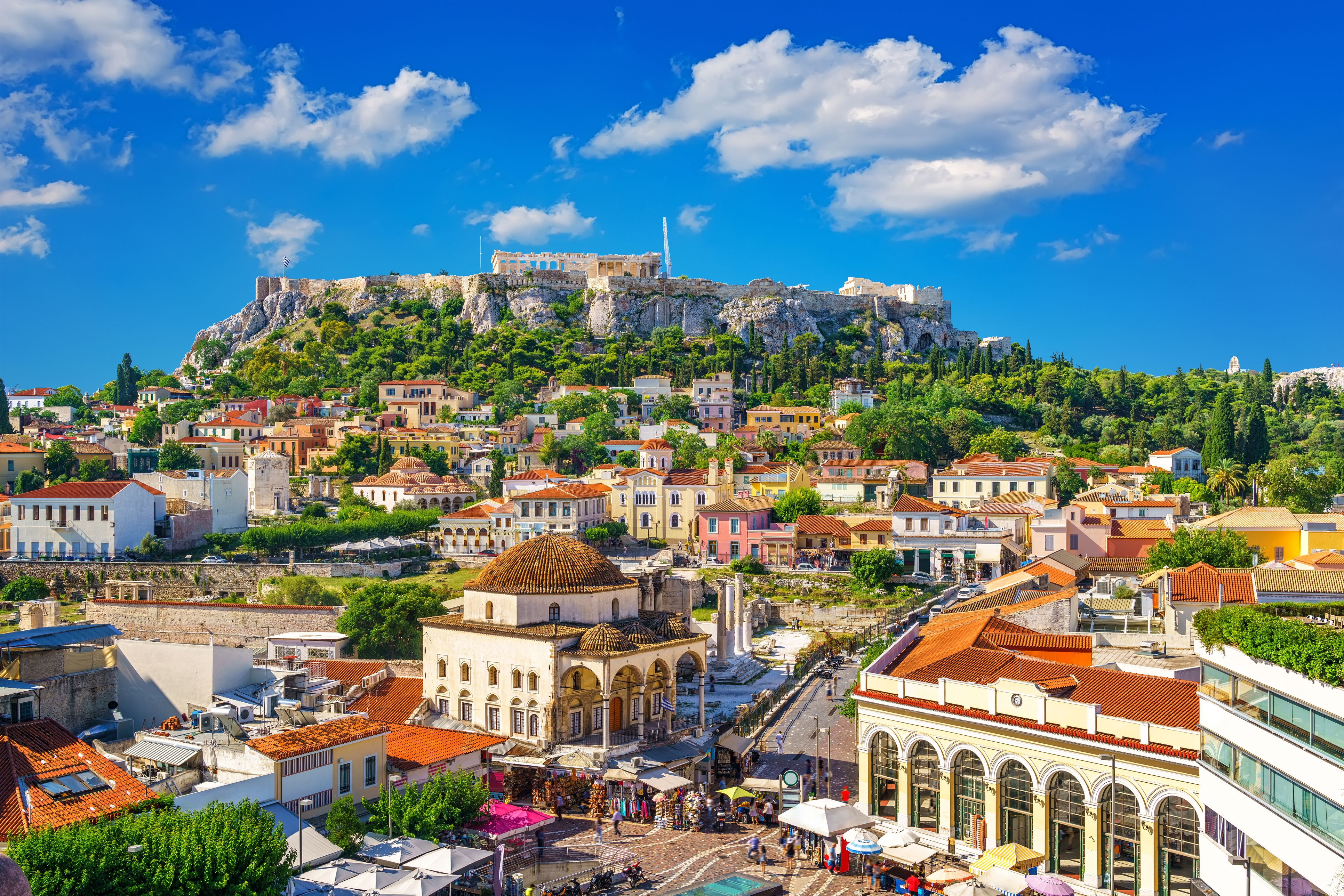 A view of Plaka in downtown Athens, Greece, with the Parthenon atop the Acropolis in the background on a sunny day