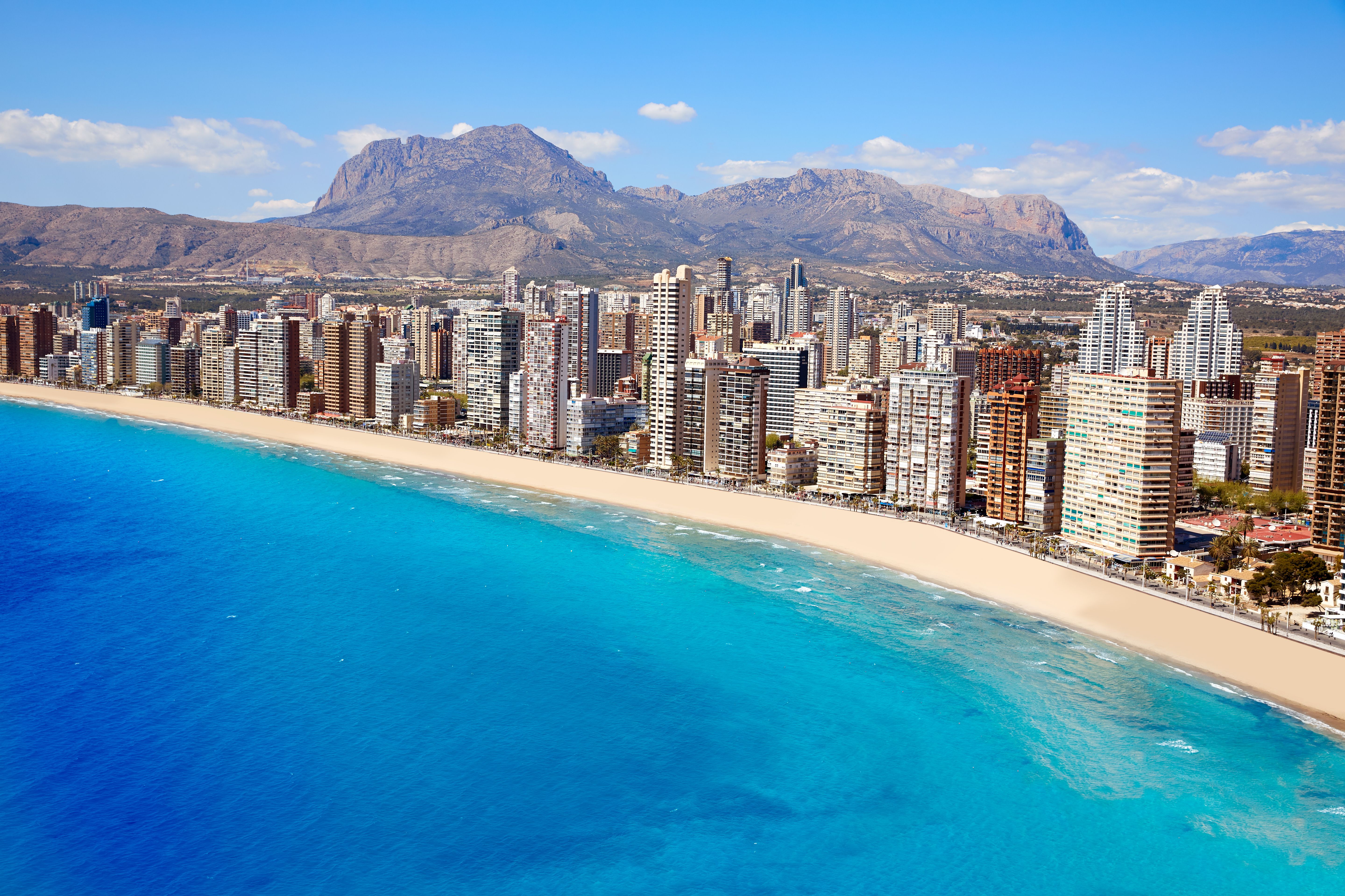 An aerial view of Benidorm coast, Spain with skyscrapers lining the beach and bright blue sea