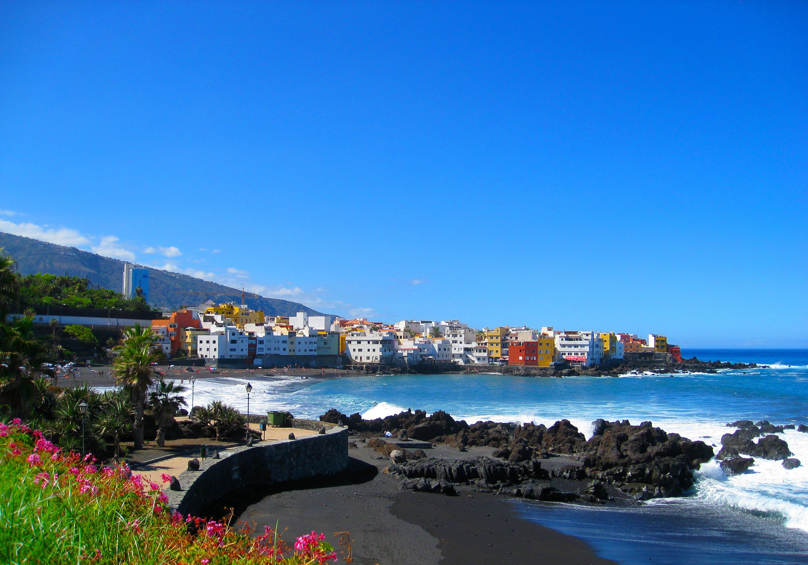 A view across a black-sand beach of Puerto de la Cruz in Tenerife, Canary Islands