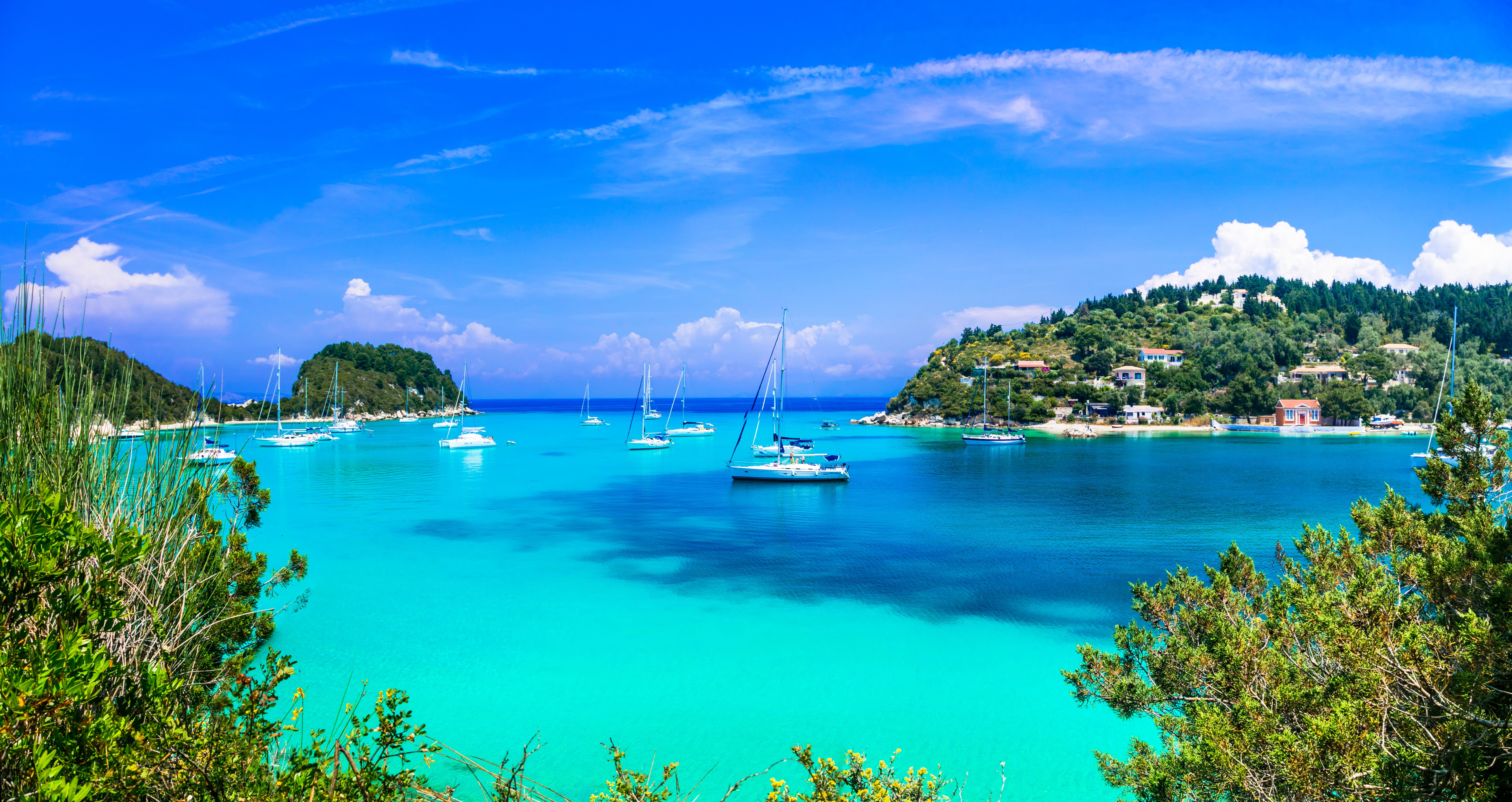 View of a bright turquoise bay with sailing boats bobbing in the water.