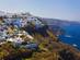 A whitewashed village clings to the side of a steep cliff overlooking the Mediterranean