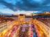 An aerial view of Bratislava Christmas market with red and white striped market stalls and brightly lit buildings