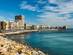 View of a hotel- and apartment-lined beach town in the Costa Blanca on a sunny day.