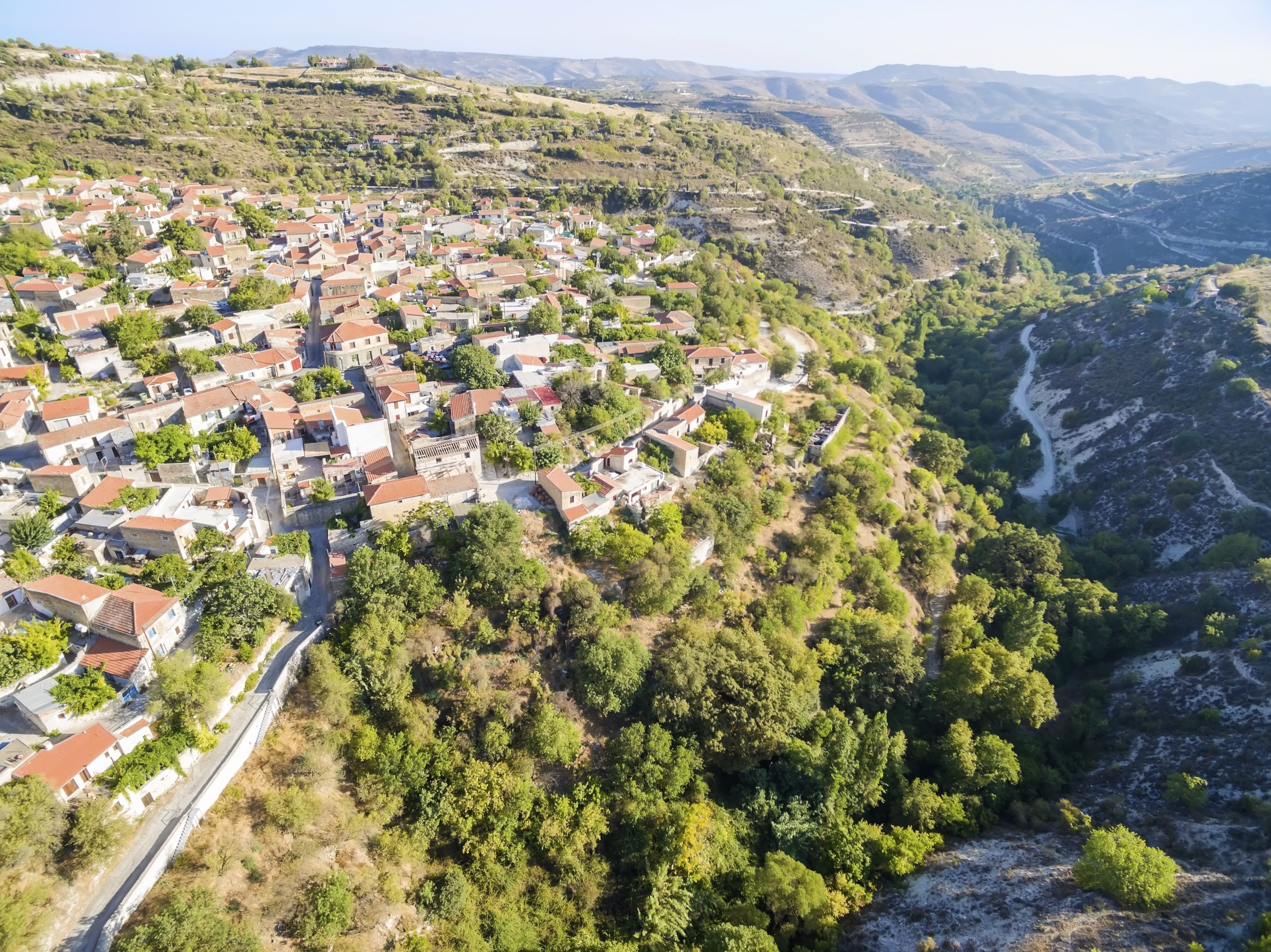 Aerial view of a picturesque village overlooking a valley with a river flowing through it.