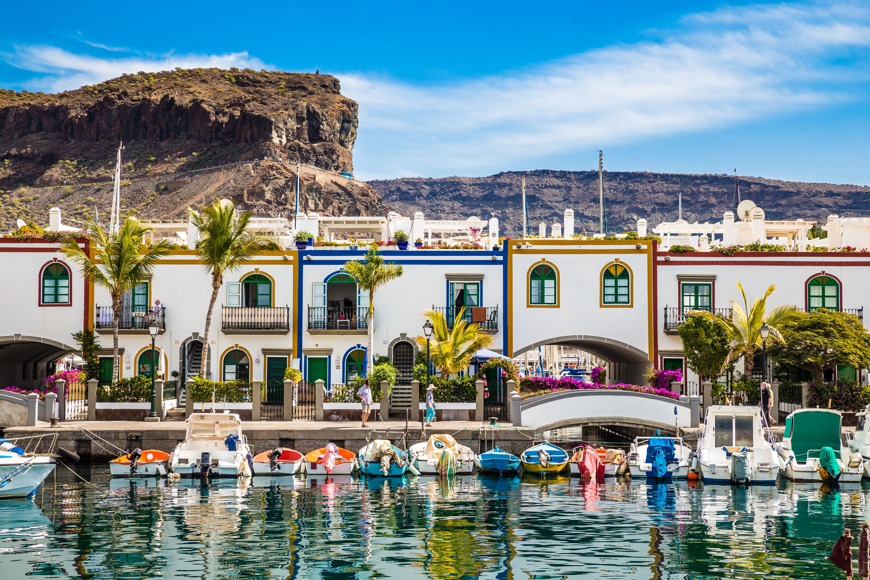 Colourful buildings and boats along a canal waterfront in the pretty town of Puerto de Mogan in Gran Canaria