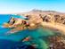 Famous bays and rock formations of Playa de Papagayo Beach in Lanzarote on a sunny, cloudless day