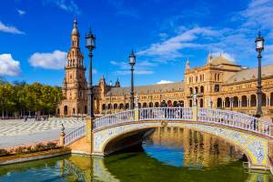 A view of the Plaza de España in Seville on a sunny day with a Venetian-style bridge in the forefront