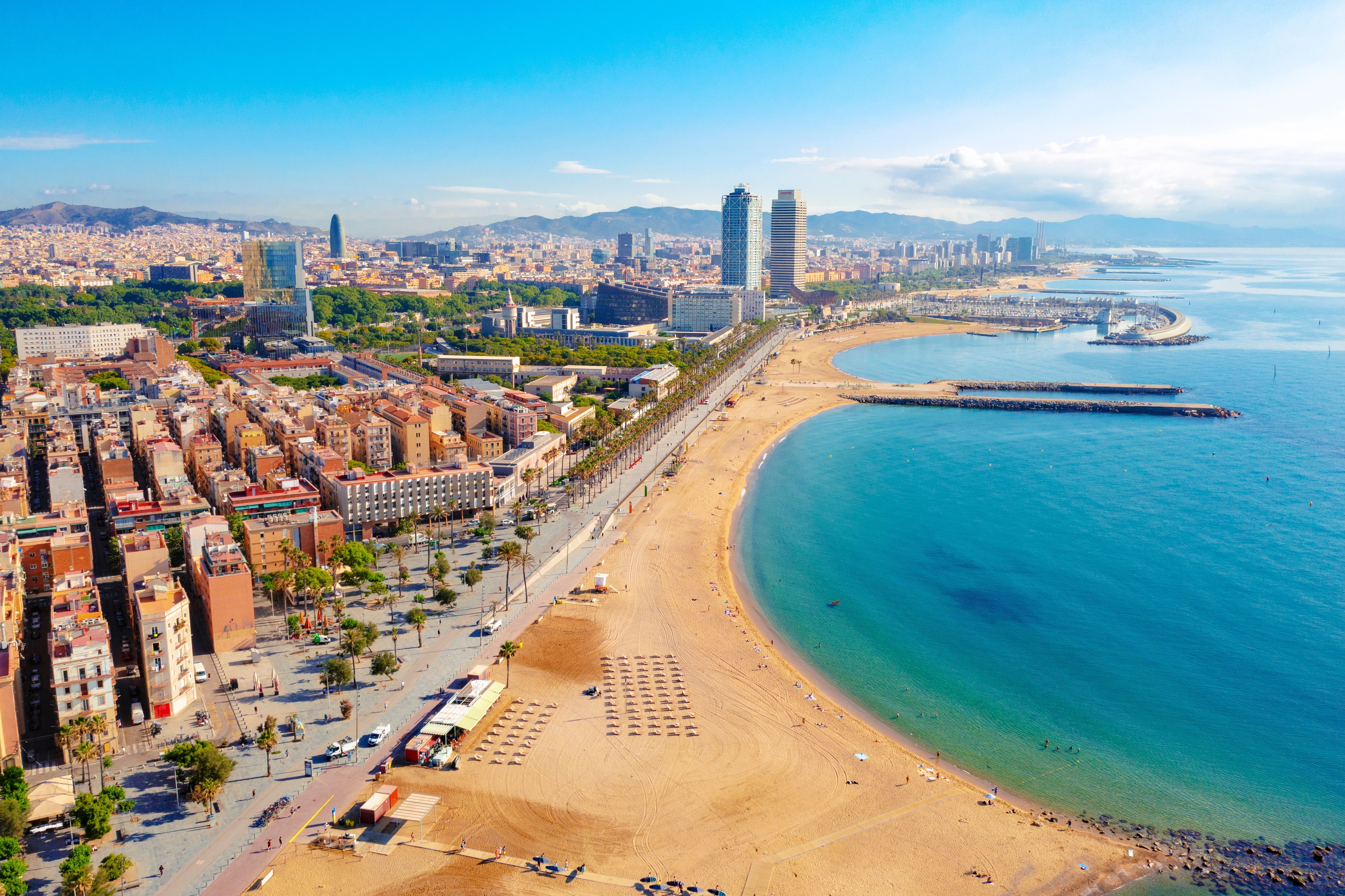 Aerial view of Barceloneta beach in Barcelona on a bright blue day