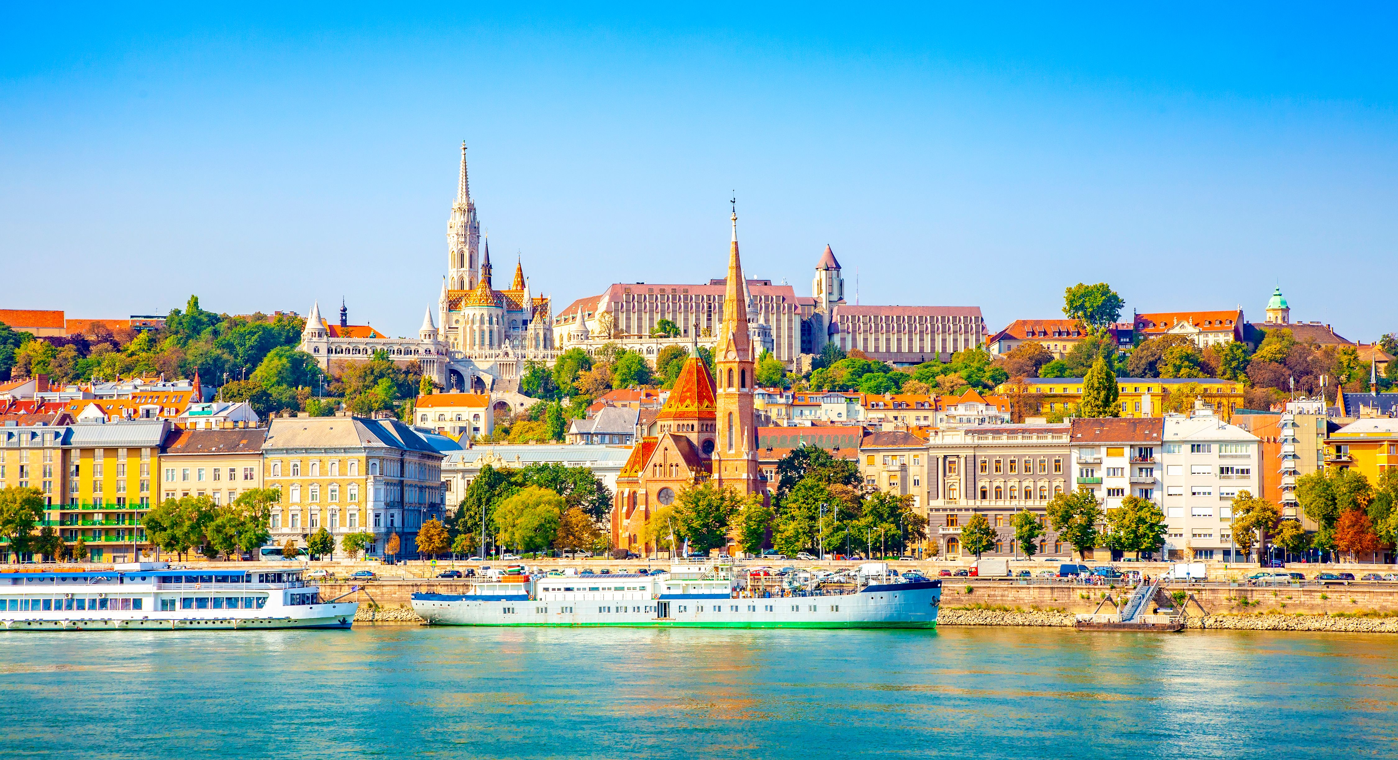 River cruise boats along the Danube River with the colourful buildings and churches of Buda in the background