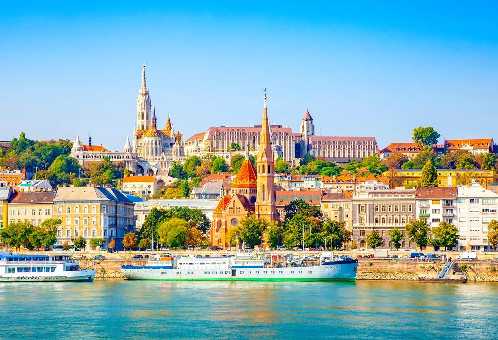 River cruise boats along the Danube River with the colourful buildings and churches of Buda in the background