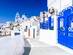An empty path leads past the ultramarine gate to a whitewashed building and leads on through a pretty, traditional Greek village