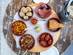 A bird's-eye-view image of six tapas dishes on an outdoor cafe table
