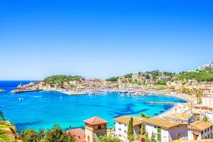 An aerial view over the harbour and beach of the resort town of Puerto de Soller in Majorca with clear blue sky