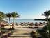 View of The Chedi Hotel private beach with palm trees and sun-loungers in El Gouna, Egypt