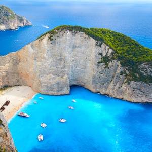 Aerial view of Shipwreck Beach in Zakynthos, known as Navagio Beach to the locals, with old shipwreck, cliffs, beach and yachts anchored