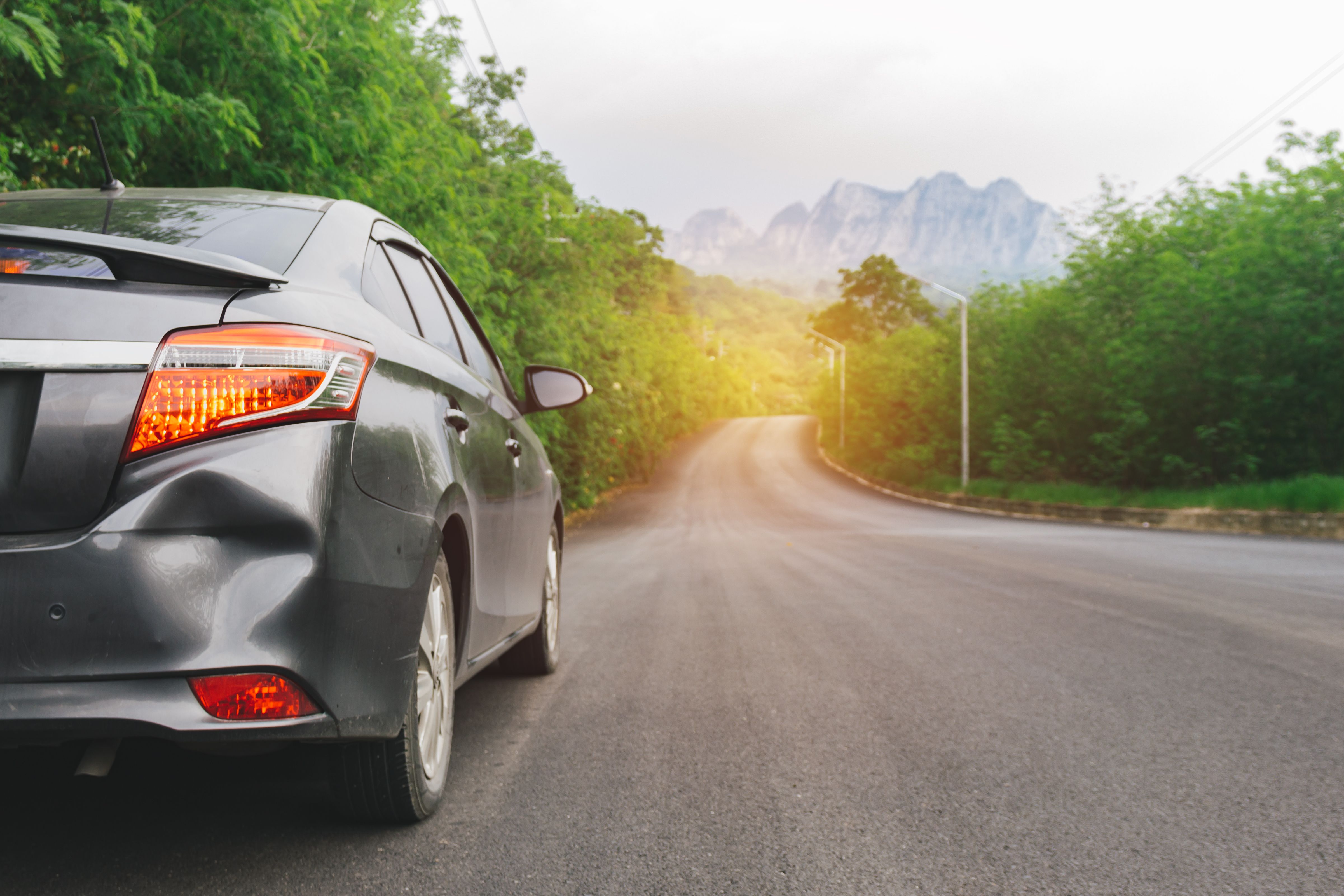 A car on the side of the road with a rear dent