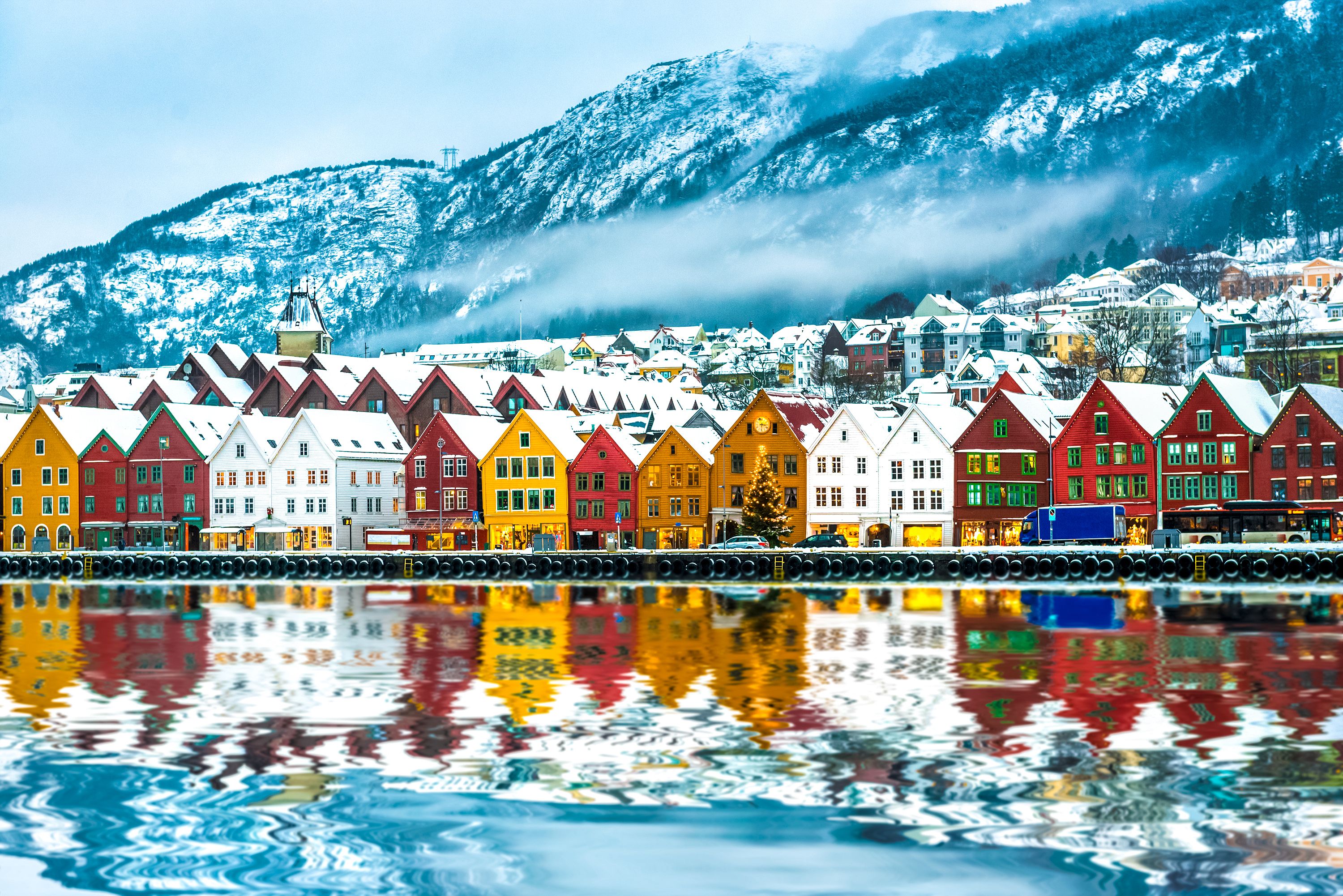 Colourful waterfront houses on a winter's day in Bergen with snowy mountains in the background