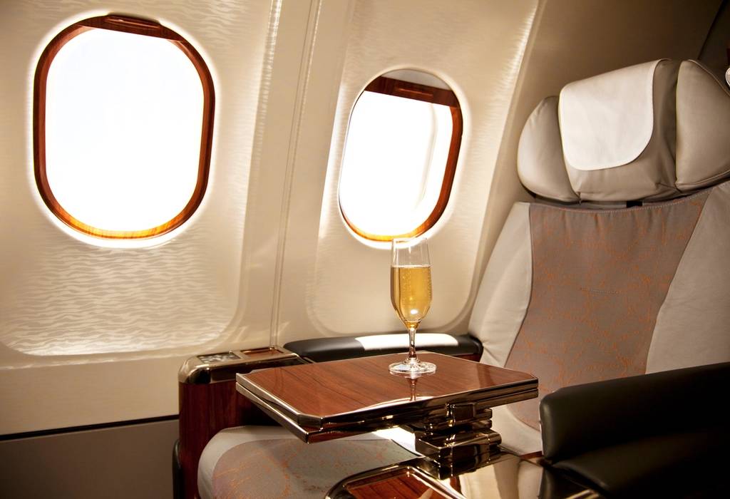 A picture of a business class seat with champagne waiting for a passenger on a flight