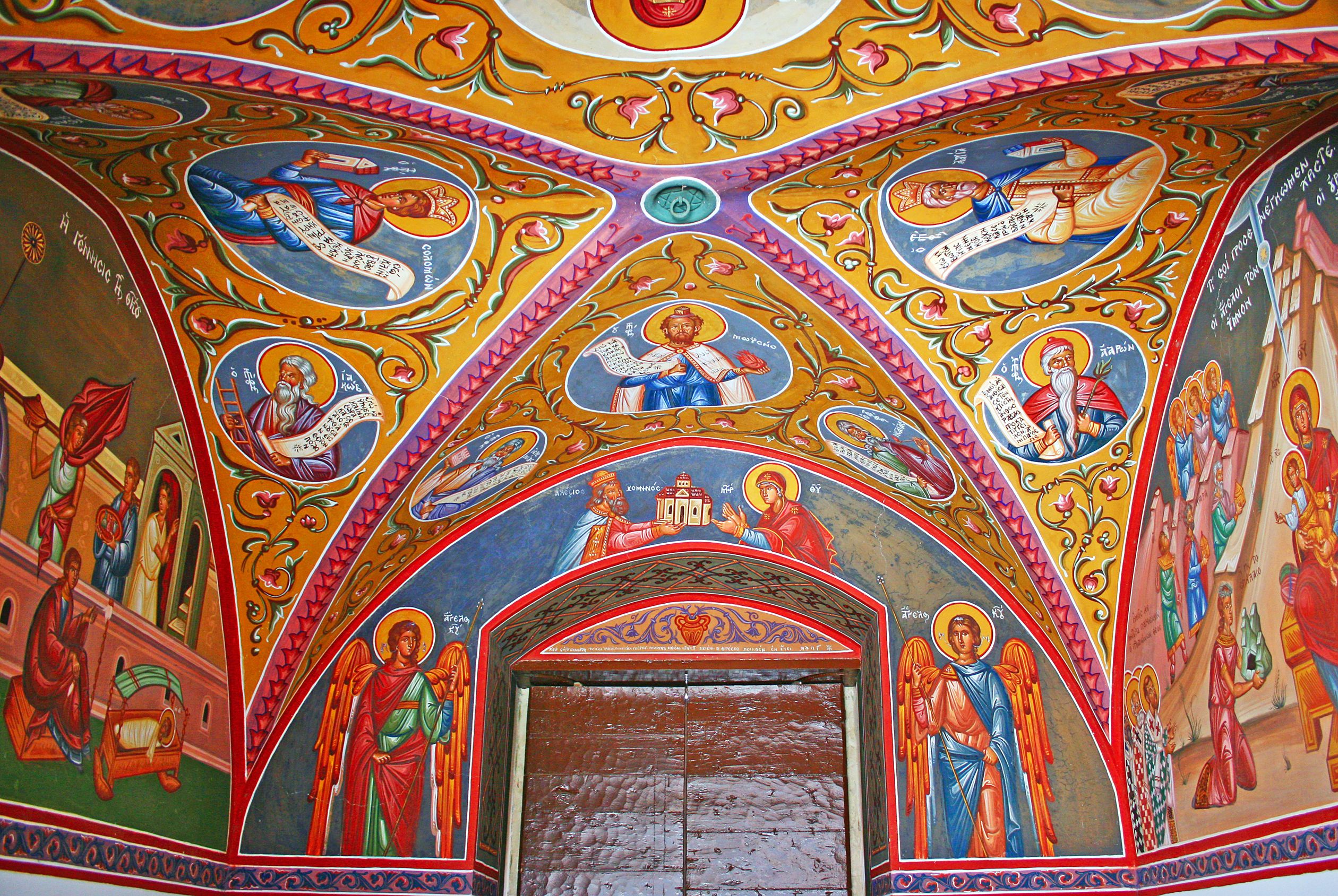 View of a arched ceiling of a monastery, colourfully painted with saints and angels.