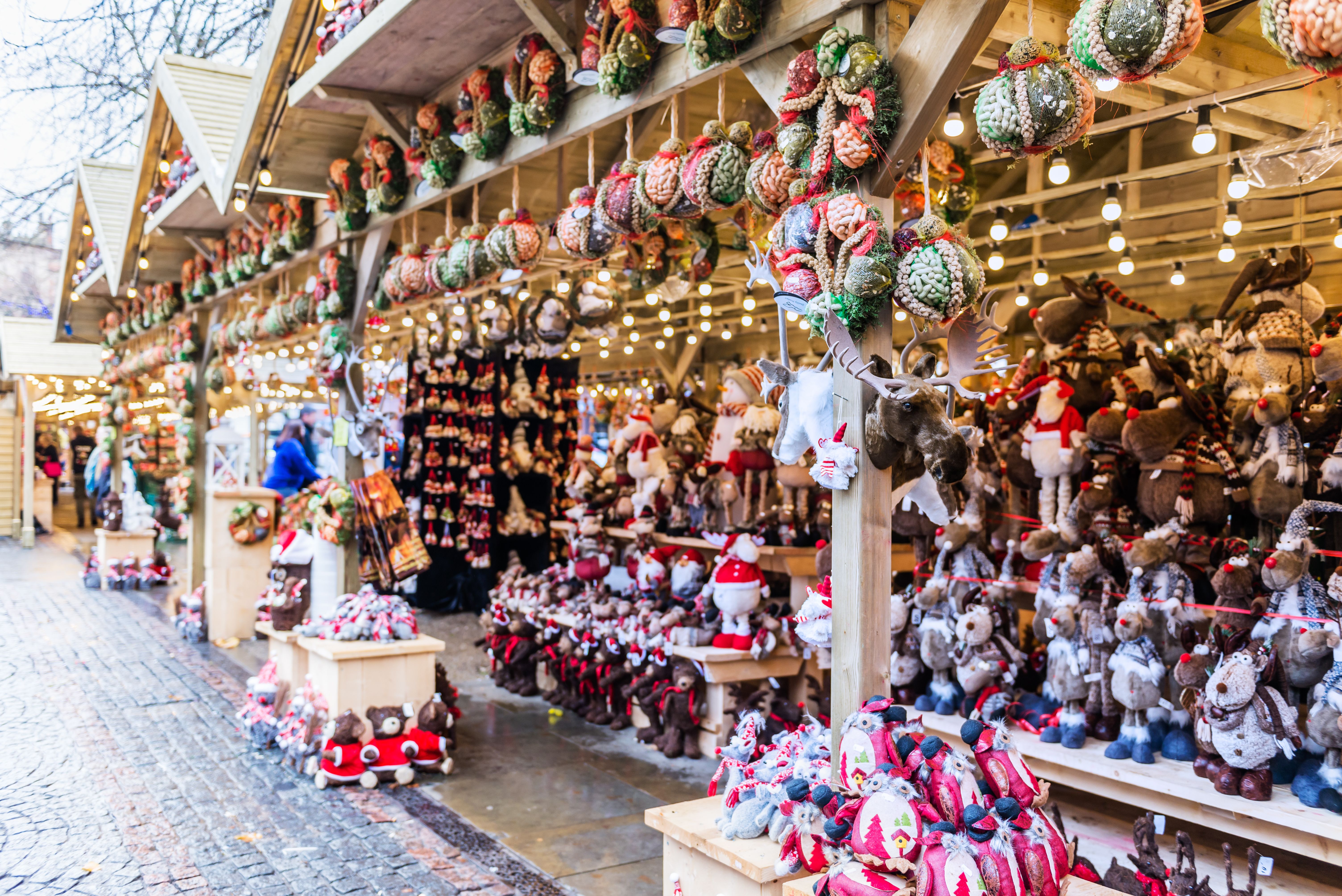 Christmas ornaments and stuffed toys such as reindeer and santas fill the wooden stalls of a Christmas market in Manchester, England
