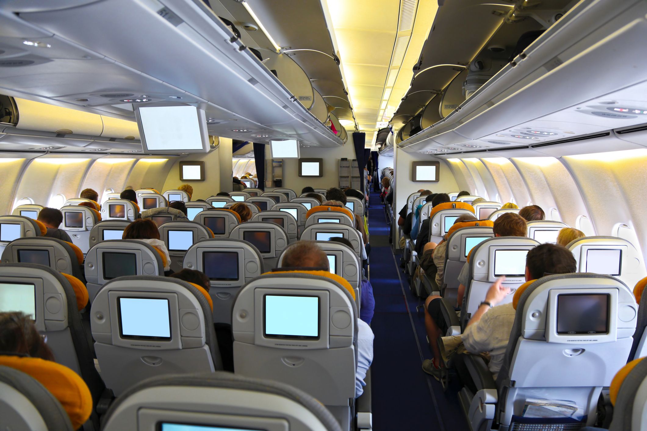 A view inside a plane of passengers watching their in-flight entertainment screens