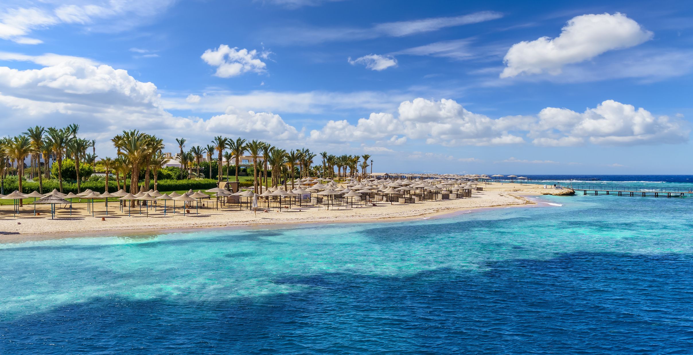 A view of a beach with thatch umbrellas in Port Ghalib, Marsa Alam, Egypt