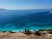 Two cyclists on a scenic winding road above famous Myrtos Beach on the island of Kefalonia, Greece