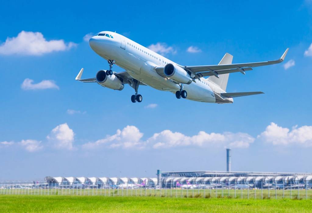 An aeroplane taking off from an airport on a bright day