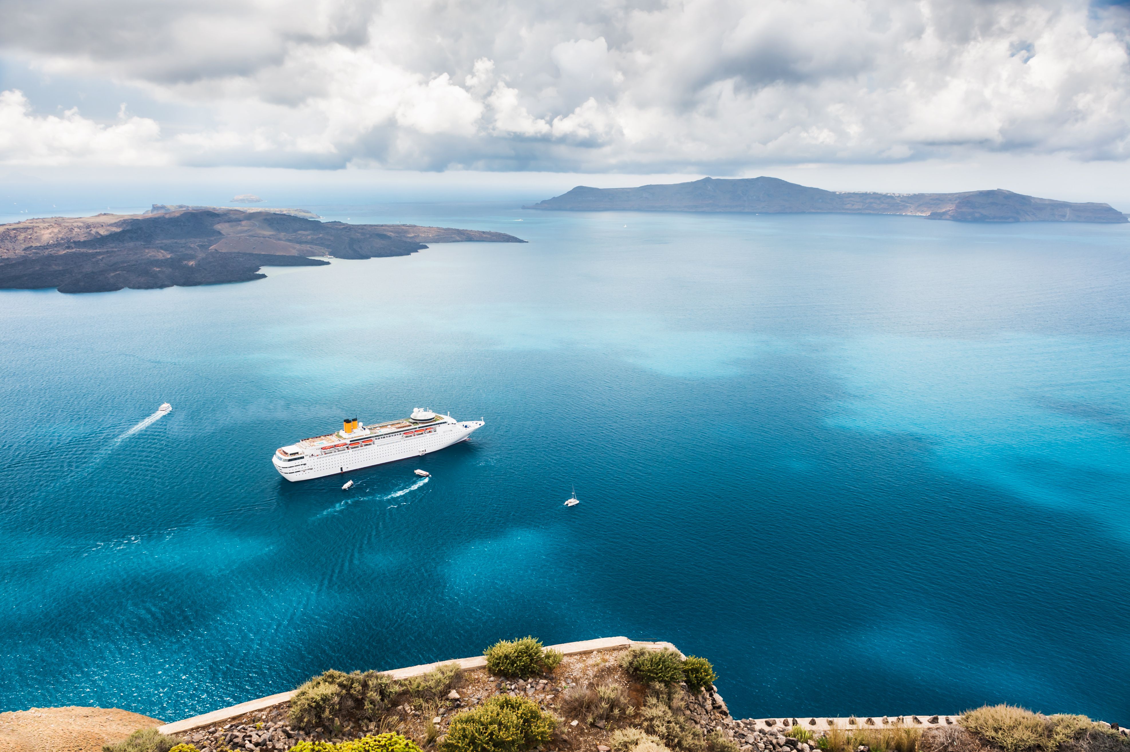 Beautiful landscape with sea view showing a cruise liner on the Aegean sea near the island of Santorini in Greece
