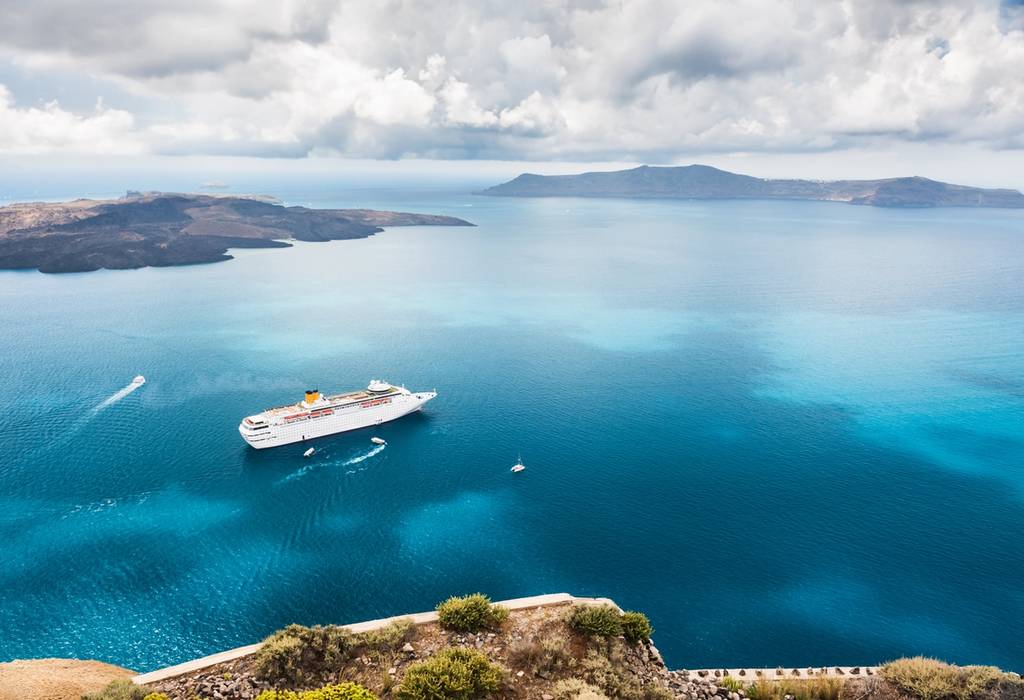 Beautiful landscape with sea view showing a cruise liner on the Aegean sea near the island of Santorini in Greece