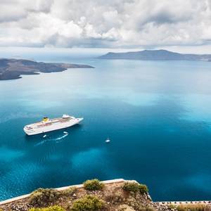 Beautiful landscape with sea view showing a cruise liner on the Aegean sea near the island of Santorini in Greece