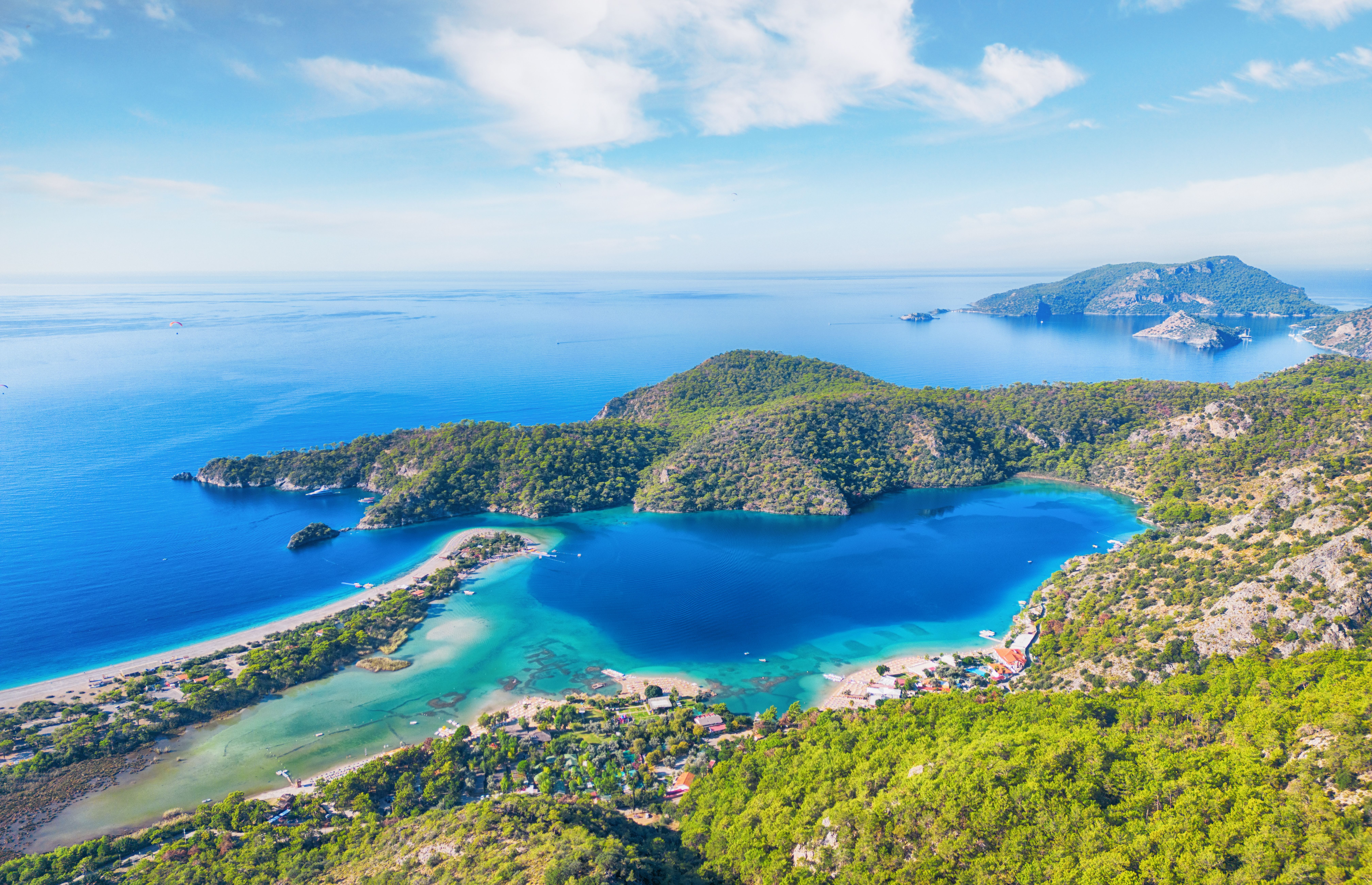 An aerial view of the Blue Lagoon in Olu Deniz, Turkey with cobalt blue water on a bright, clear sky day