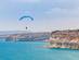 Paraglider soaring over the cliffs of Kurion and mediterranean sea landscape in Limassol, Cyprus