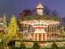 A view of the Christmas market in Tivoli Gardens, Copenhagen with brightly lit fairground rides and Christmas trees
